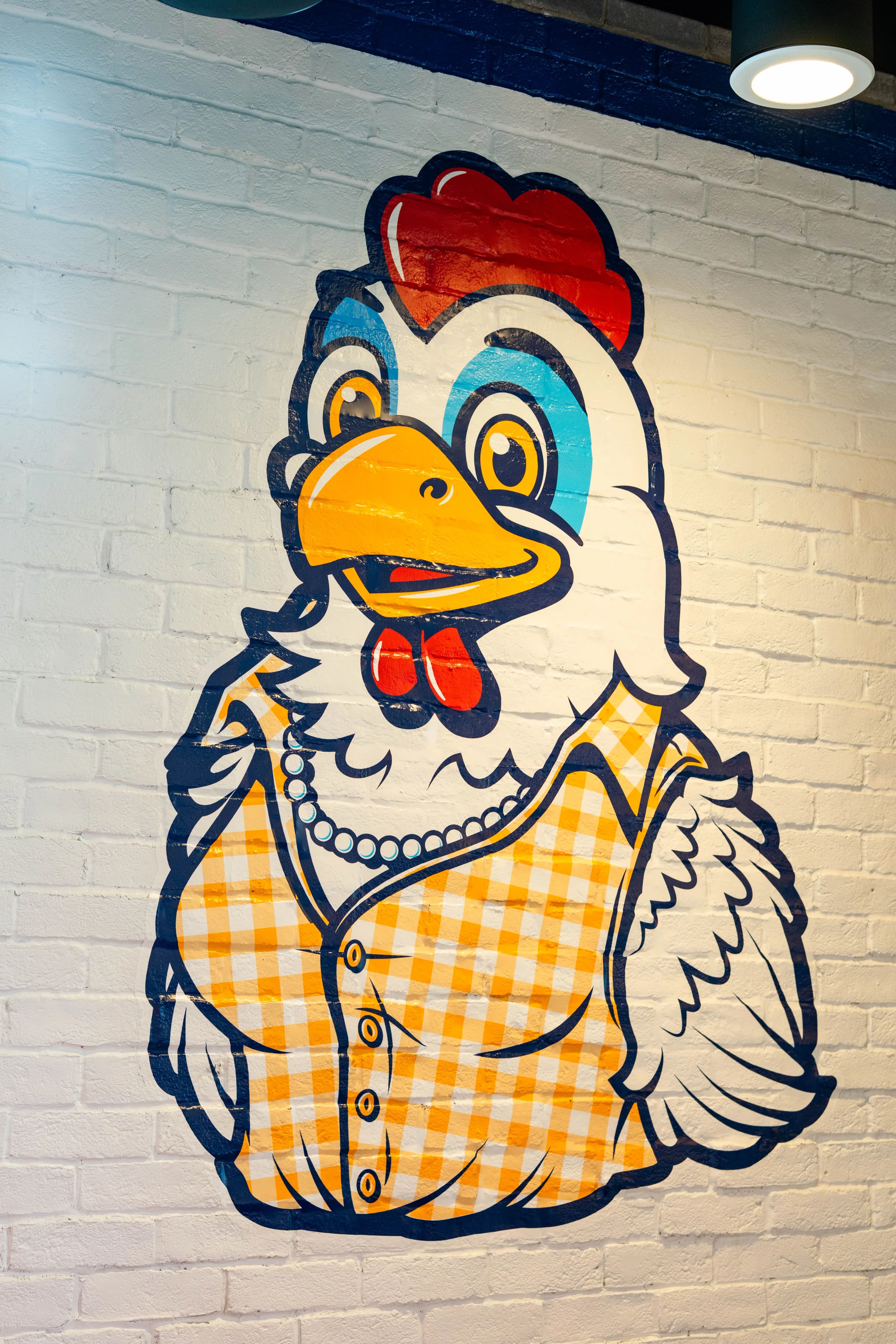 Mural of the Pretty Hens rooster mascot on a brick wall