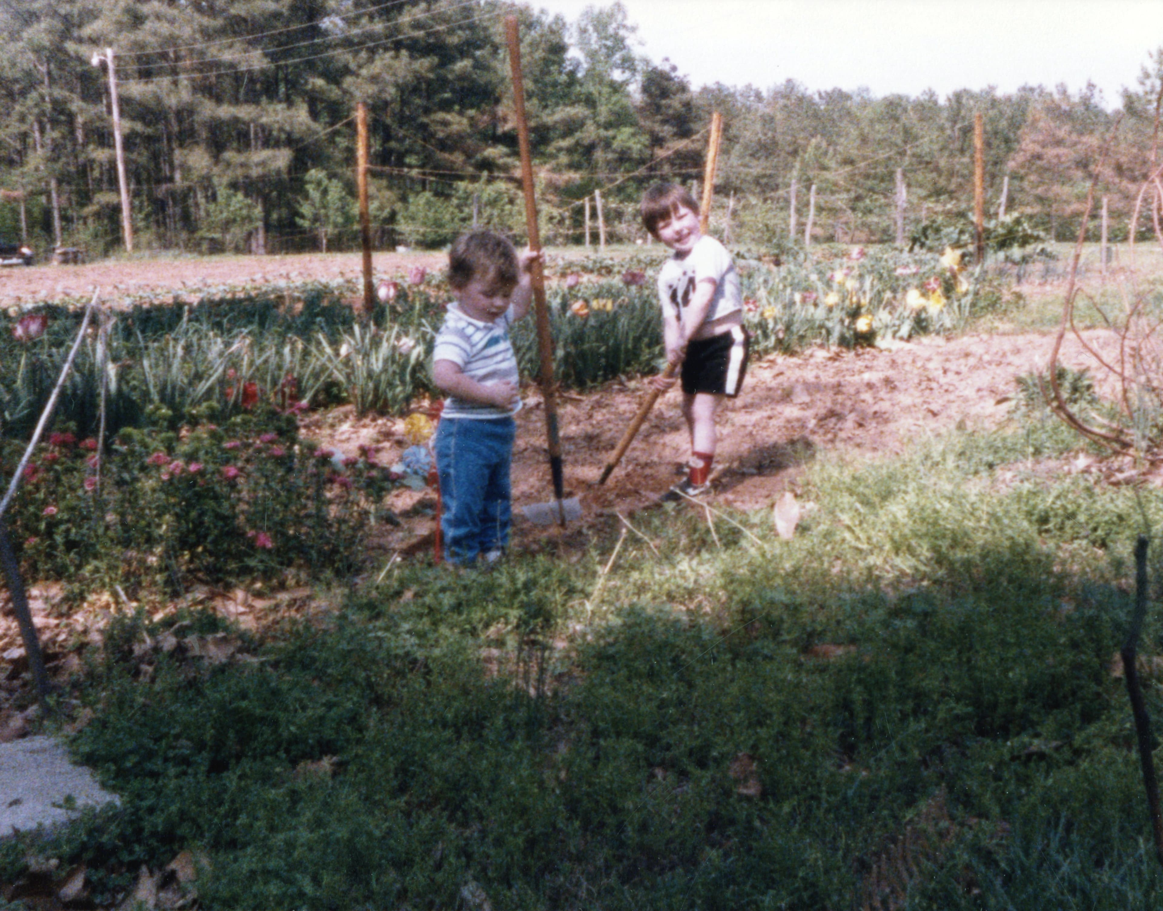 Childhood photo of two Pretty Hens founders working in the family garden